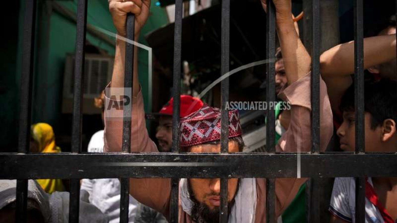 Pria Muslim India di depan teralis pisahkan area penghancuran toko di New Delhi
Sumber : AP Photo/Altaf Qadri
