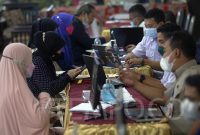 Petugas melayani orang tua murid yang berkonsultasi terkait pendaftaran daring Penerimaan Peserta Didik Baru (Tempo.co)
